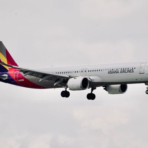 Asiana Airlines Airbus A321 aircraft flying mid-air with landing gear down.