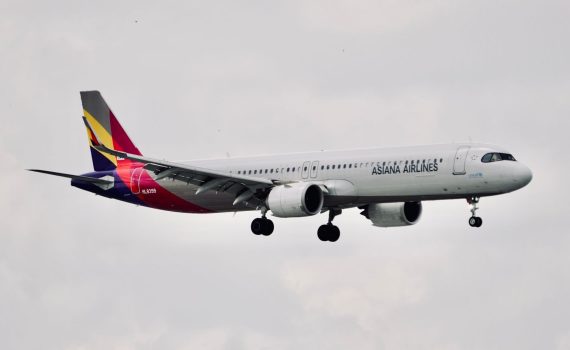 Asiana Airlines Airbus A321 aircraft flying mid-air with landing gear down.